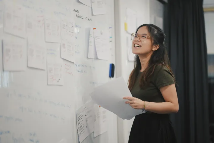 woman using a whiteboard to brainstorm notes