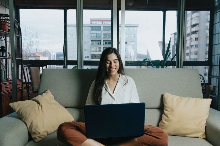 woman using laptop while sitting on couch